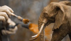 Sculpteur Damien Colcombet patinant le bronze